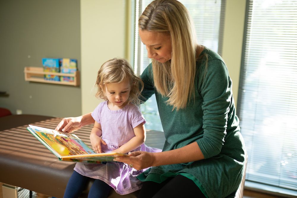 adult reading a book to a child 